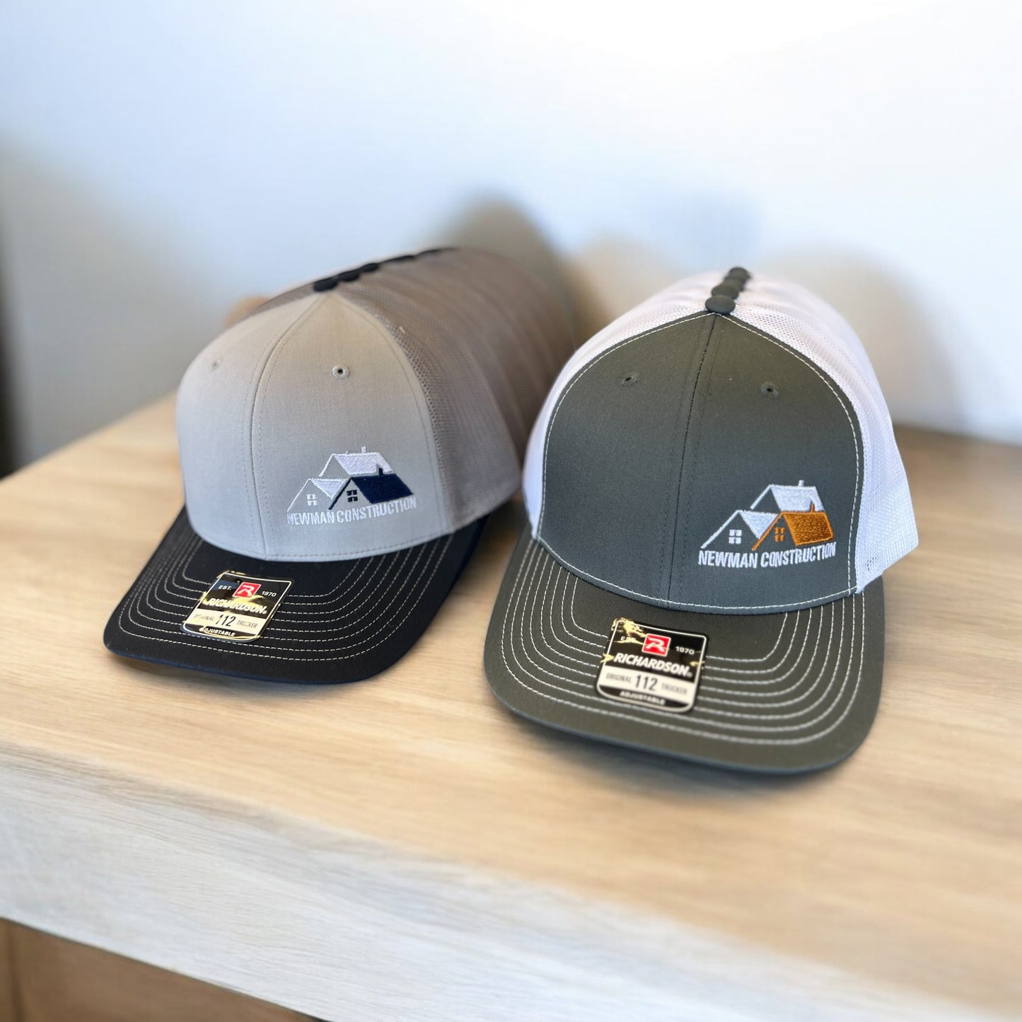 line of grey and green hats with embroidered logos
