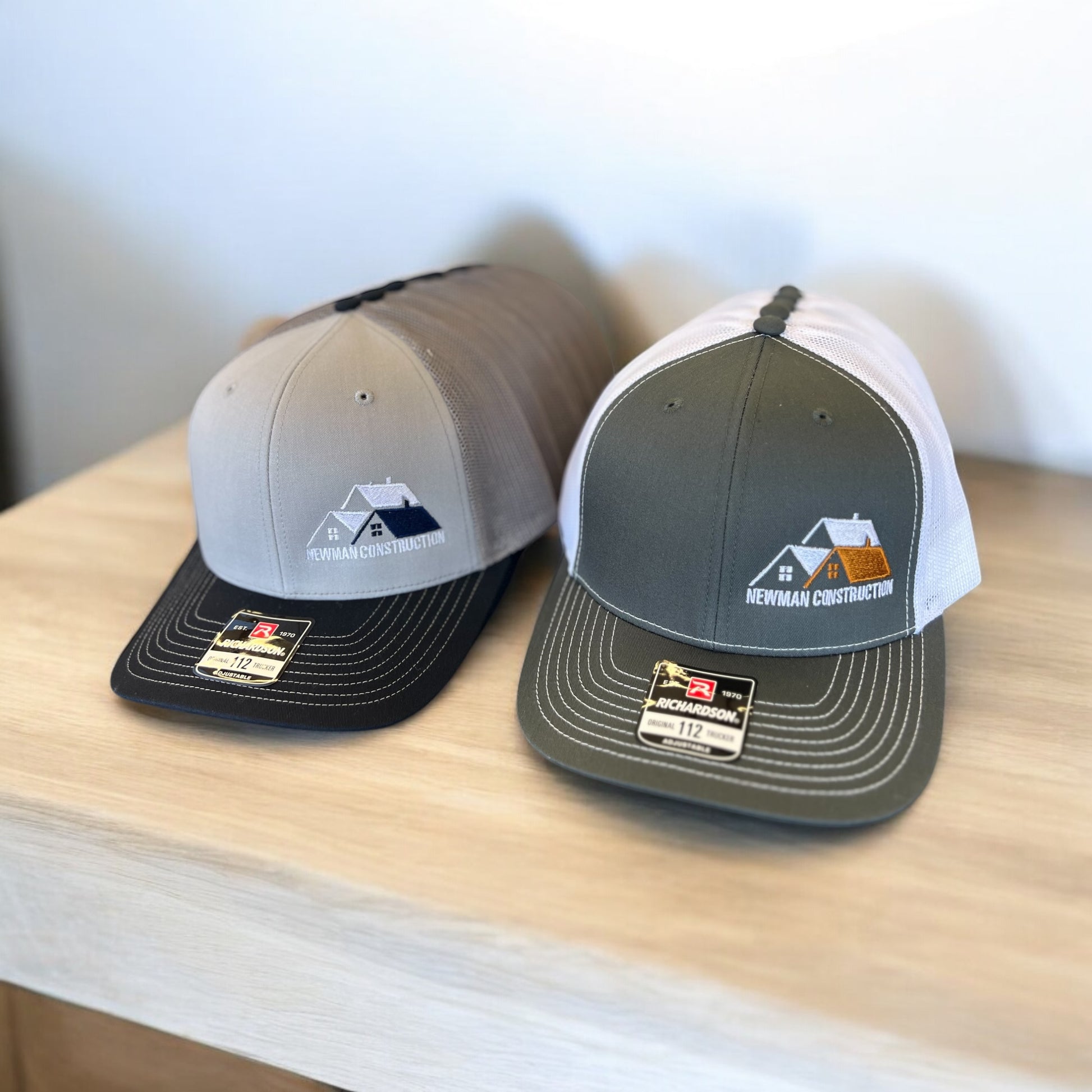 line of grey and green hats with embroidered logos 