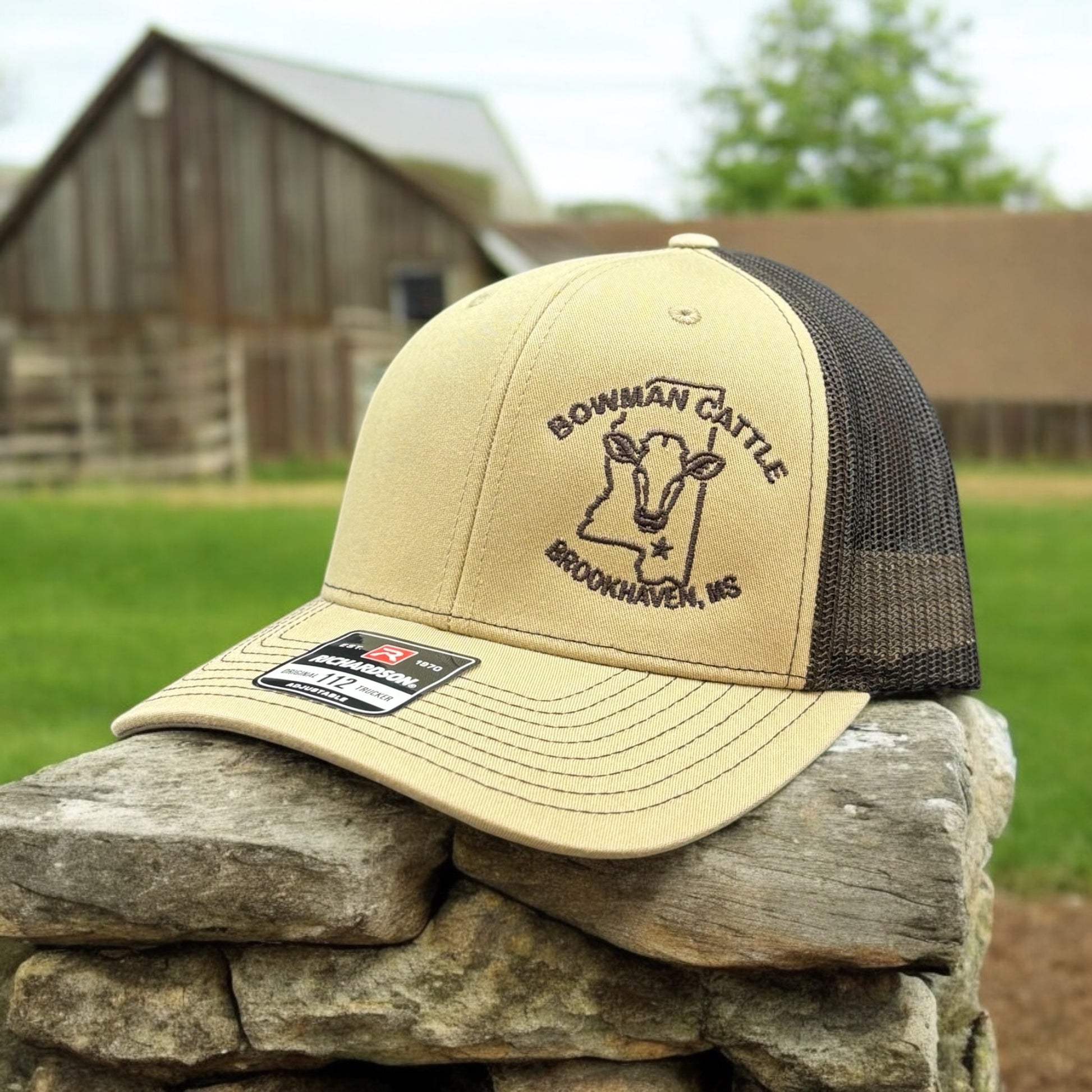 Tan hat with a logo embroidered on it outdoor