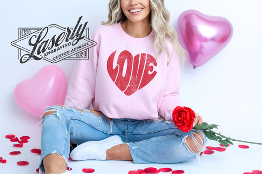 Model wearing a pink sweatshirt with "love" shaped as a heart